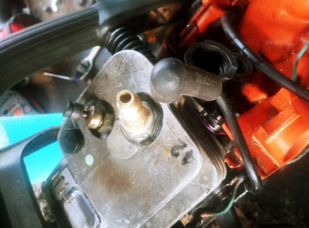 Altered spark plug for pressurizing the crankcase.